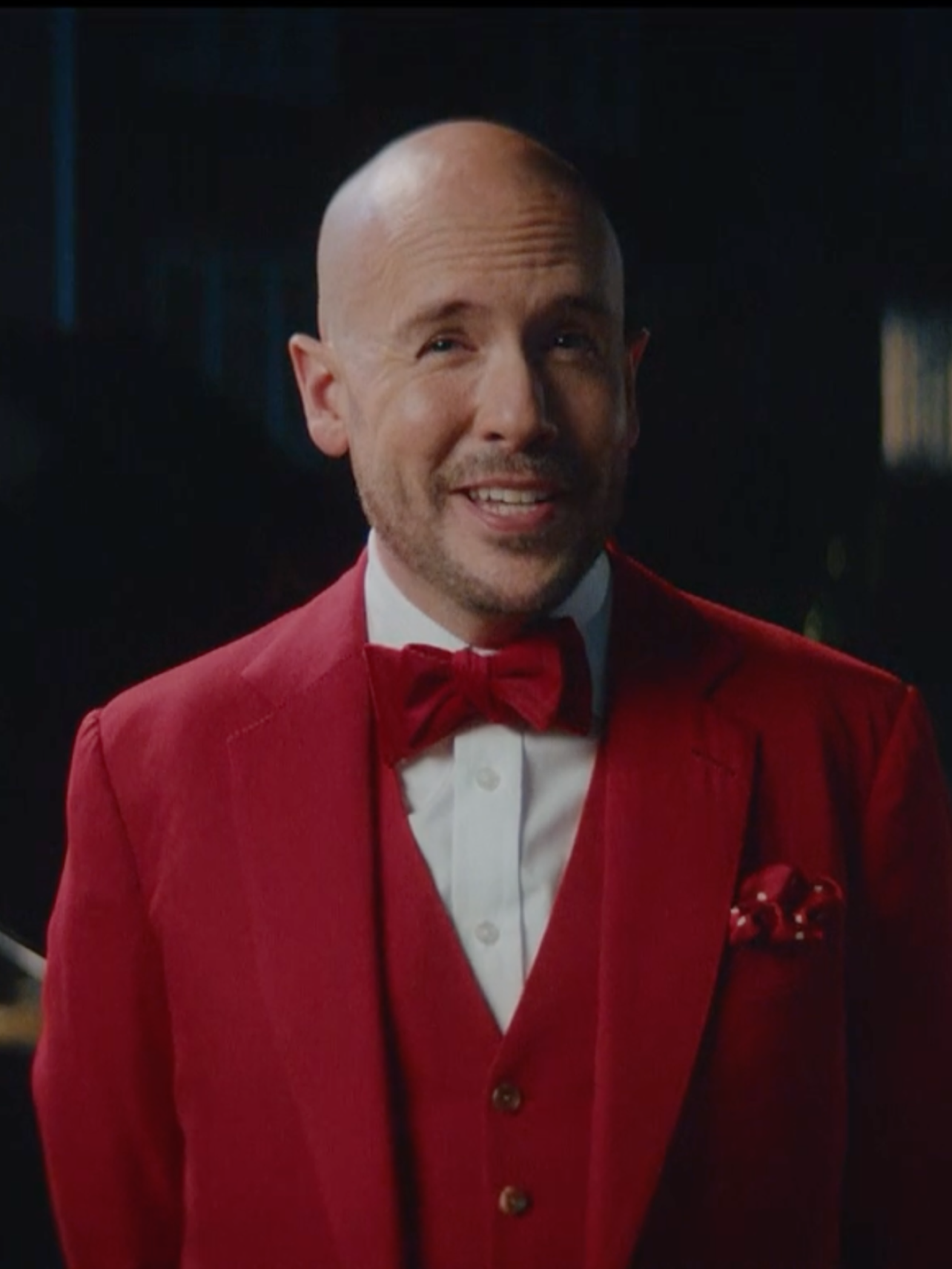 Man in a red suit with a red bow tie